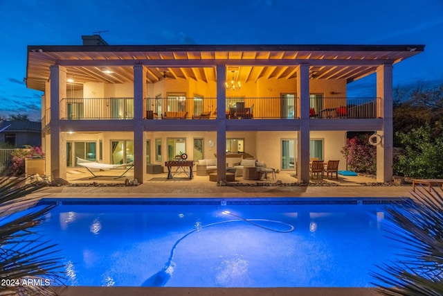 15857 E Ponderosa Dr, Fountain Hills, AZ 85268 - back of house at night featuring a balcony, outdoor lounge area, a patio, and an outdoor pool