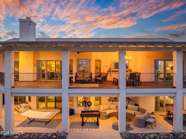 15857 E Ponderosa Dr, Fountain Hills, AZ 85268 - back of house at dusk with an outdoor hangout area, stucco siding, a chimney, and a patio