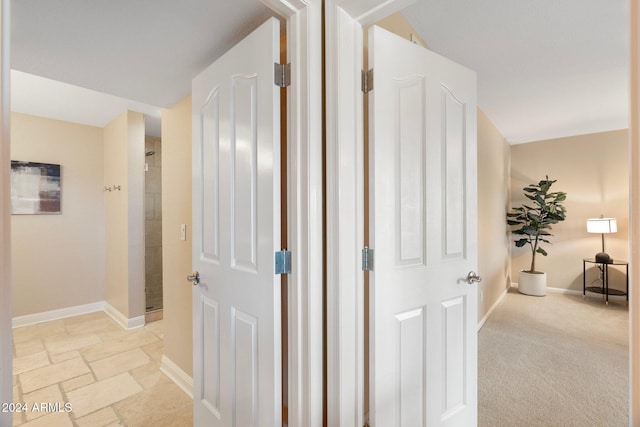 hall with light colored carpet