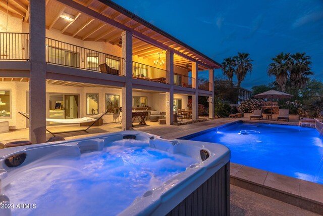 view of swimming pool with a hot tub, pool water feature, and a patio area