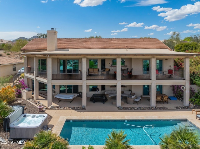 rear view of house featuring a pool with hot tub, a patio, and outdoor lounge area