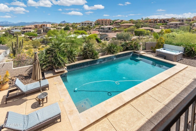 view of swimming pool featuring a mountain view, a hot tub, and a patio area