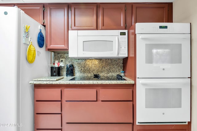 kitchen featuring light stone countertops, white appliances, and tasteful backsplash