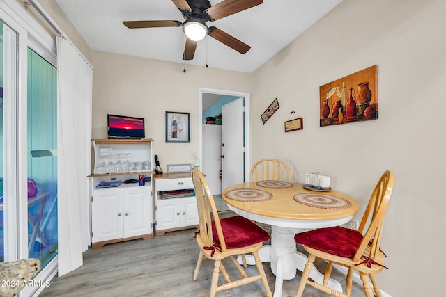 dining space featuring ceiling fan, a textured ceiling, and light wood-type flooring