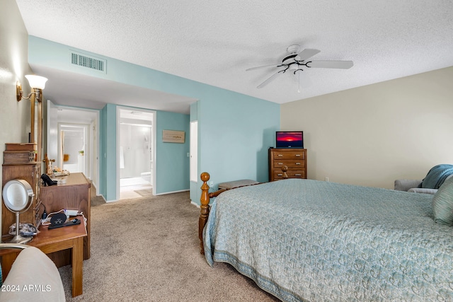 bedroom featuring a textured ceiling, ceiling fan, light carpet, and ensuite bath