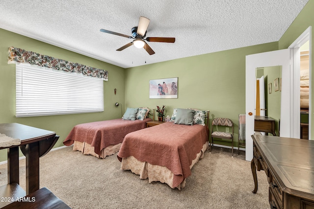 carpeted bedroom featuring ceiling fan and a textured ceiling