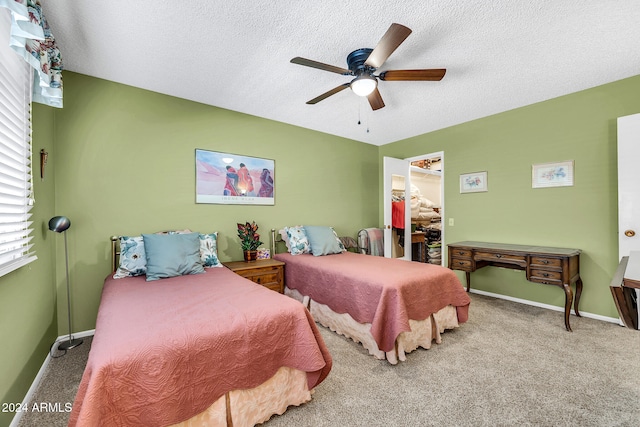 carpeted bedroom with a textured ceiling and ceiling fan