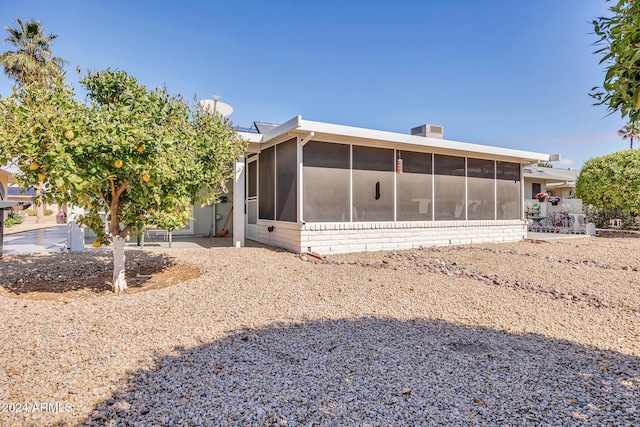 back of property with a sunroom