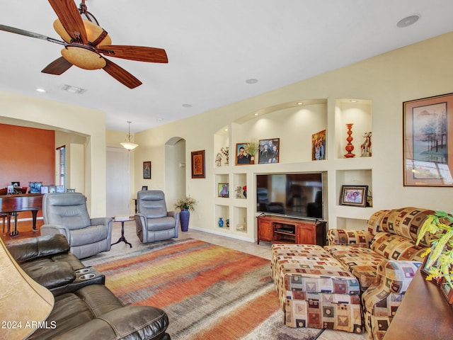 living room with built in features and ceiling fan