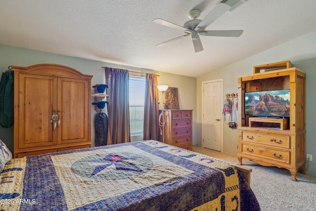 bedroom featuring lofted ceiling, ceiling fan, a textured ceiling, and light colored carpet