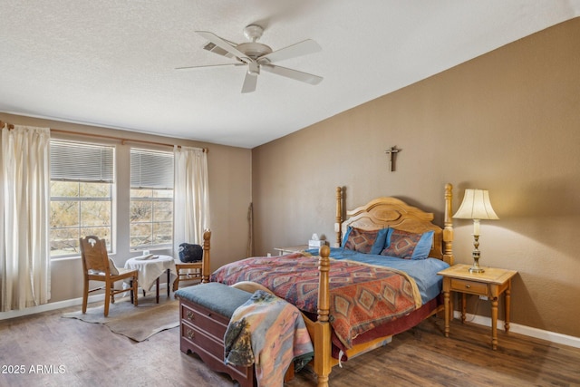 bedroom with a ceiling fan, a textured ceiling, baseboards, and wood finished floors