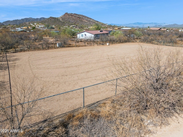 exterior space with an enclosed area, fence, a mountain view, and a rural view