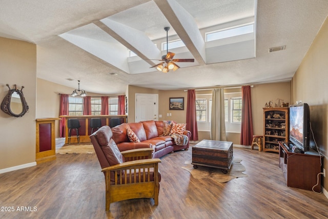 living room with a healthy amount of sunlight, a textured ceiling, visible vents, and wood finished floors