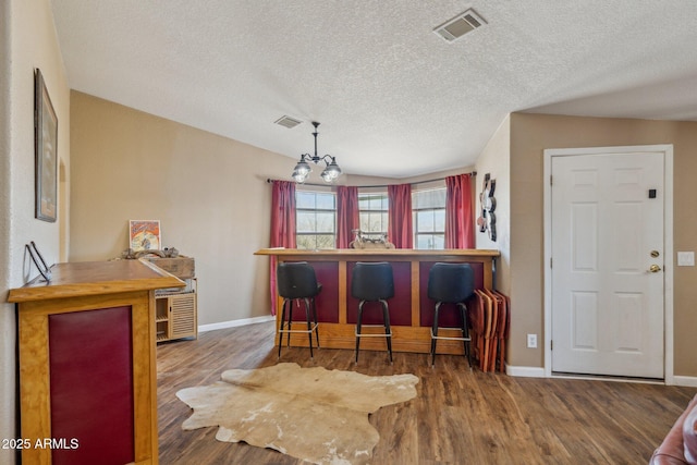 dining room with baseboards, visible vents, and wood finished floors