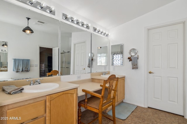 bathroom featuring a shower with shower door, a sink, and double vanity