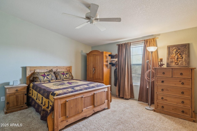 bedroom featuring a ceiling fan, a textured ceiling, and light colored carpet