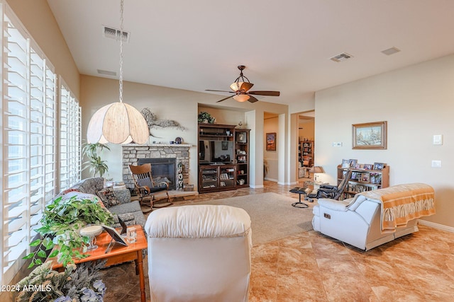 living room featuring ceiling fan and a fireplace