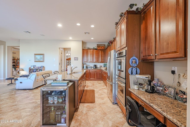 kitchen with appliances with stainless steel finishes, light stone countertops, sink, and wine cooler