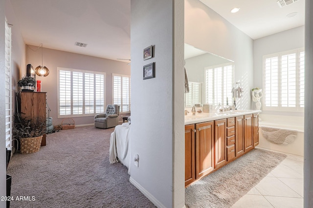 bathroom with tile patterned floors, a bathtub, and vanity