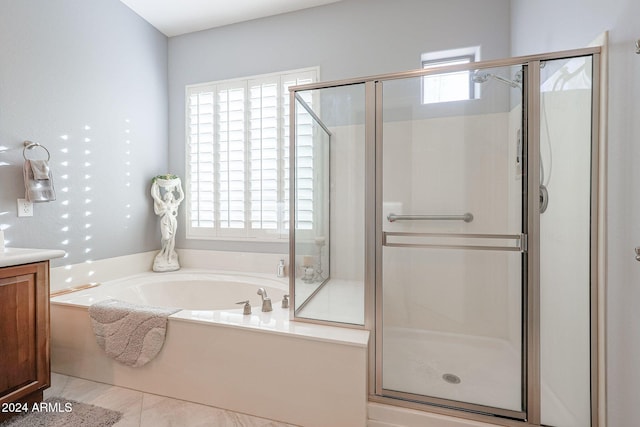 bathroom featuring tile patterned flooring, vanity, plus walk in shower, and a wealth of natural light