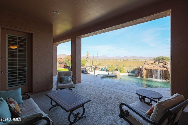 view of patio / terrace featuring a fenced in pool, pool water feature, and a mountain view