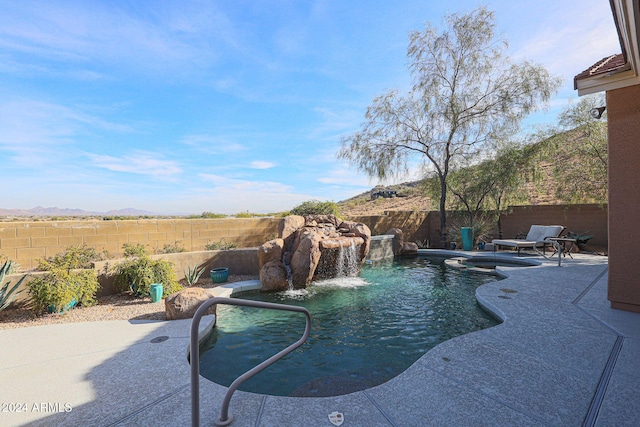 view of pool with a mountain view, pool water feature, and a patio