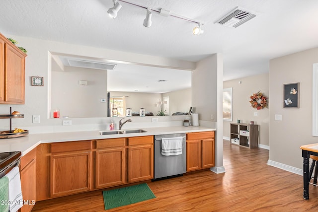 kitchen featuring kitchen peninsula, stove, stainless steel dishwasher, sink, and light hardwood / wood-style flooring