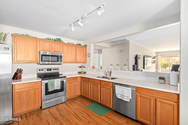 kitchen featuring stainless steel appliances, light hardwood / wood-style floors, and sink