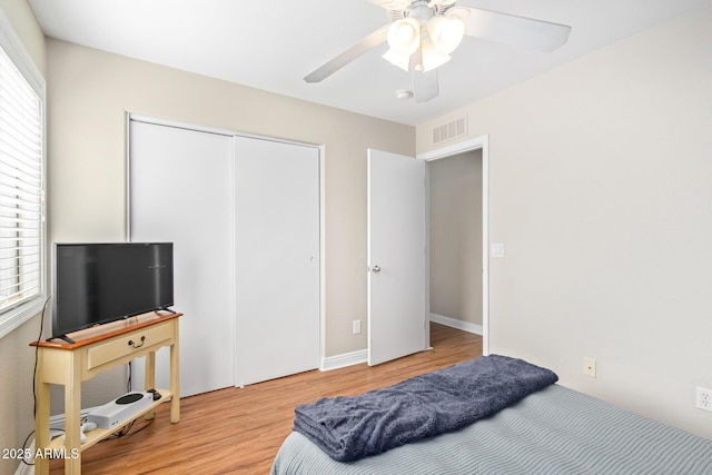 bedroom with ceiling fan, a closet, and light hardwood / wood-style flooring