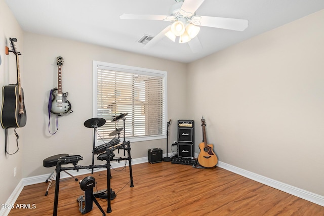 exercise room with hardwood / wood-style flooring and ceiling fan