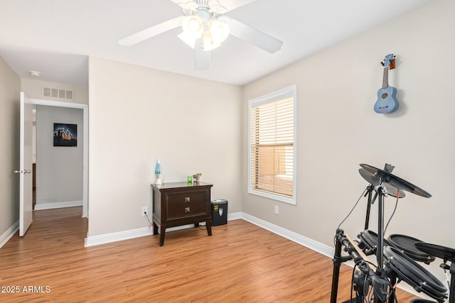 exercise area with light hardwood / wood-style floors and ceiling fan