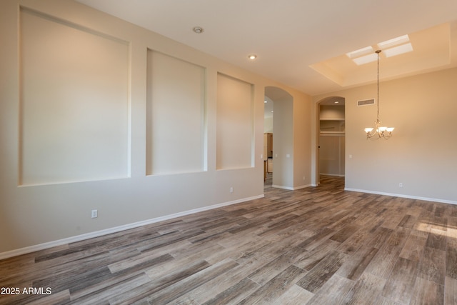 1555 E Monterey St, Chandler, AZ 85225 - empty room with a chandelier, wood finished floors, arched walkways, baseboards, and a skylight