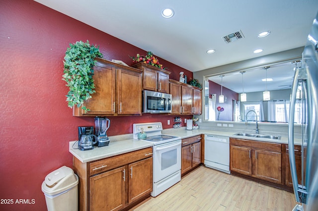 kitchen featuring a sink, appliances with stainless steel finishes, light countertops, and visible vents