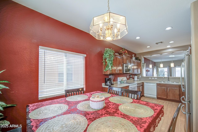 dining area with visible vents, recessed lighting, light wood-style flooring, and an inviting chandelier