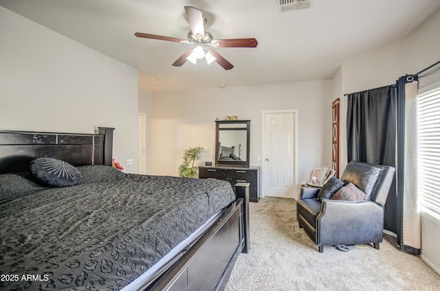 bedroom featuring a ceiling fan, baseboards, visible vents, and light carpet