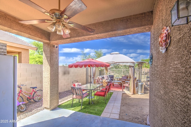view of patio with an outdoor living space, a ceiling fan, a gazebo, a fenced backyard, and outdoor dining space