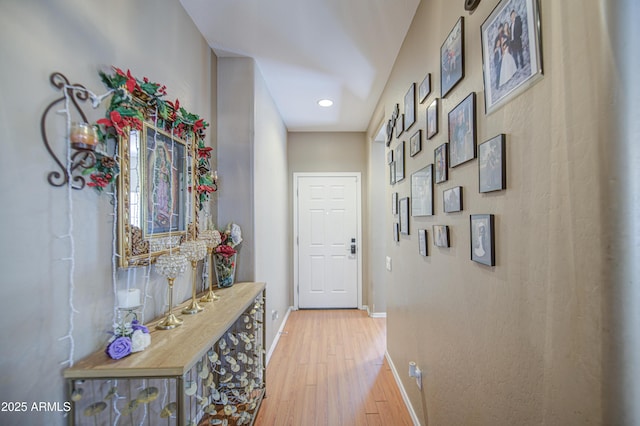 hall with baseboards, recessed lighting, and light wood-style flooring