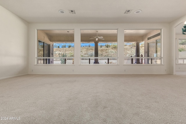 spare room featuring carpet floors, ceiling fan, and a healthy amount of sunlight