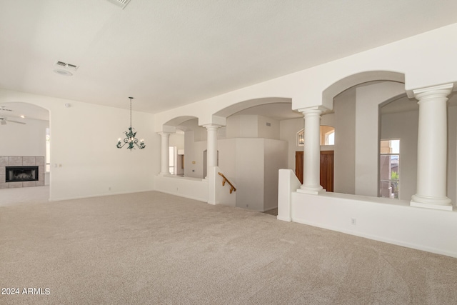 empty room with a fireplace, carpet floors, and ornate columns