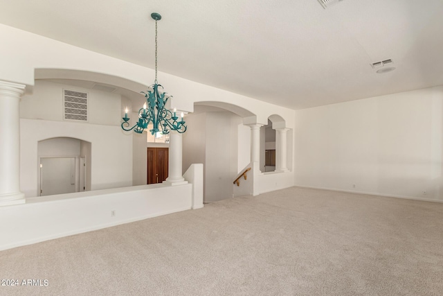 carpeted empty room featuring arched walkways, visible vents, and ornate columns