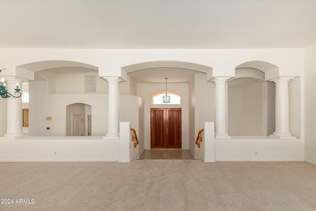 entrance foyer with decorative columns and light carpet