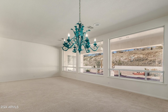 unfurnished dining area featuring a chandelier, carpet floors, visible vents, and baseboards