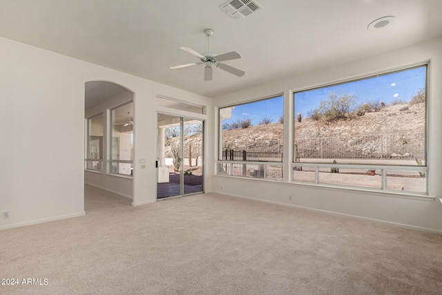 empty room with ceiling fan, carpet flooring, visible vents, and baseboards