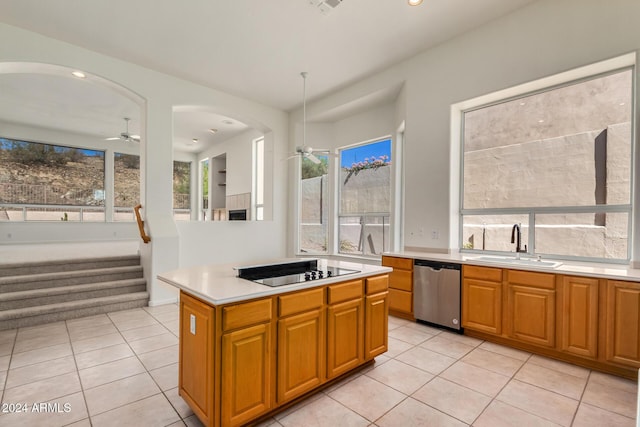 kitchen featuring a ceiling fan, dishwasher, black electric stovetop, light countertops, and a sink