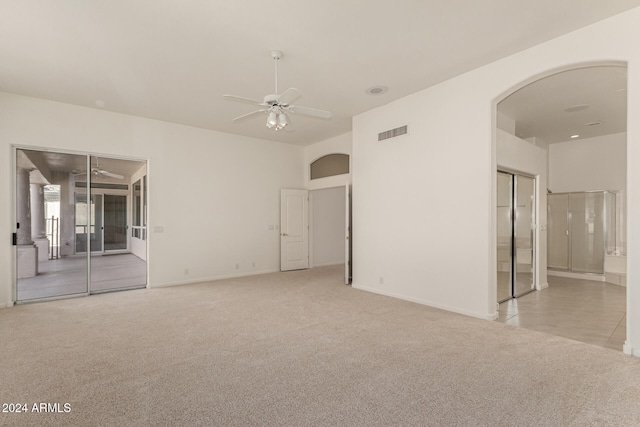 carpeted spare room featuring ceiling fan