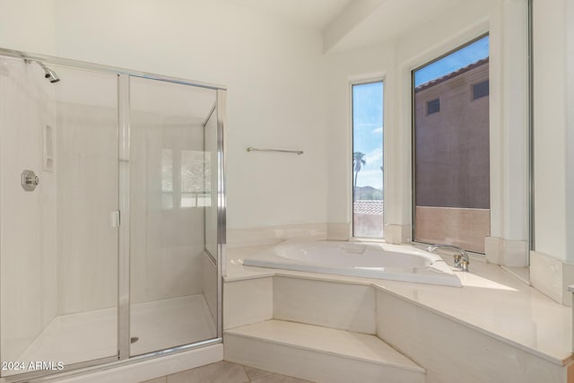 full bathroom with a shower stall and a bath