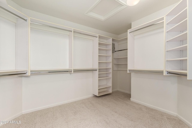 spacious closet with attic access and carpet