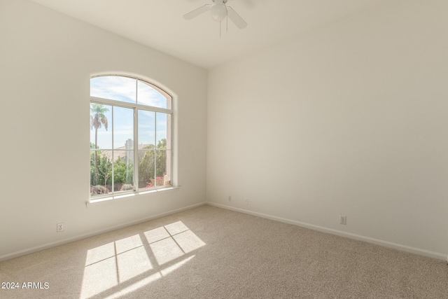 unfurnished room with ceiling fan, baseboards, and light colored carpet