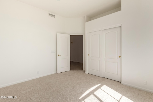 unfurnished bedroom featuring carpet floors, a closet, visible vents, and baseboards