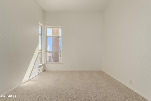 empty room with light carpet and baseboards